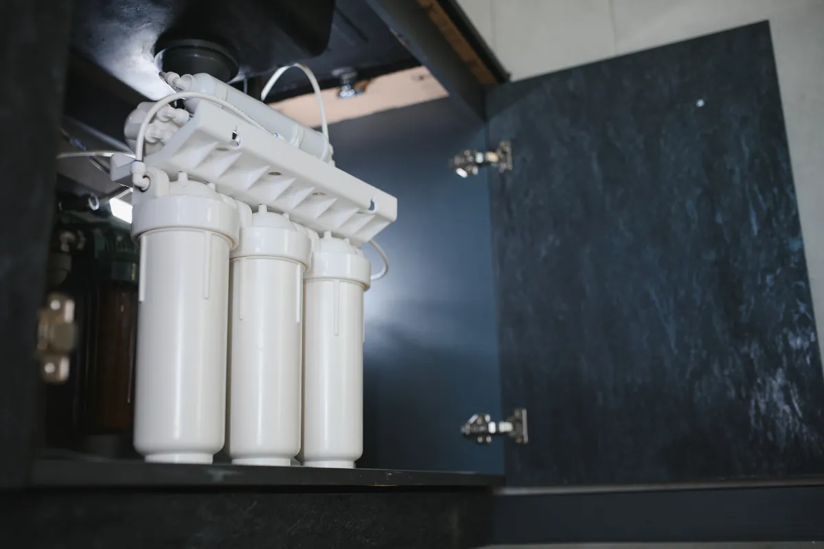 Under sink water softener filtration system with three stage filters installed in Portland home kitchen