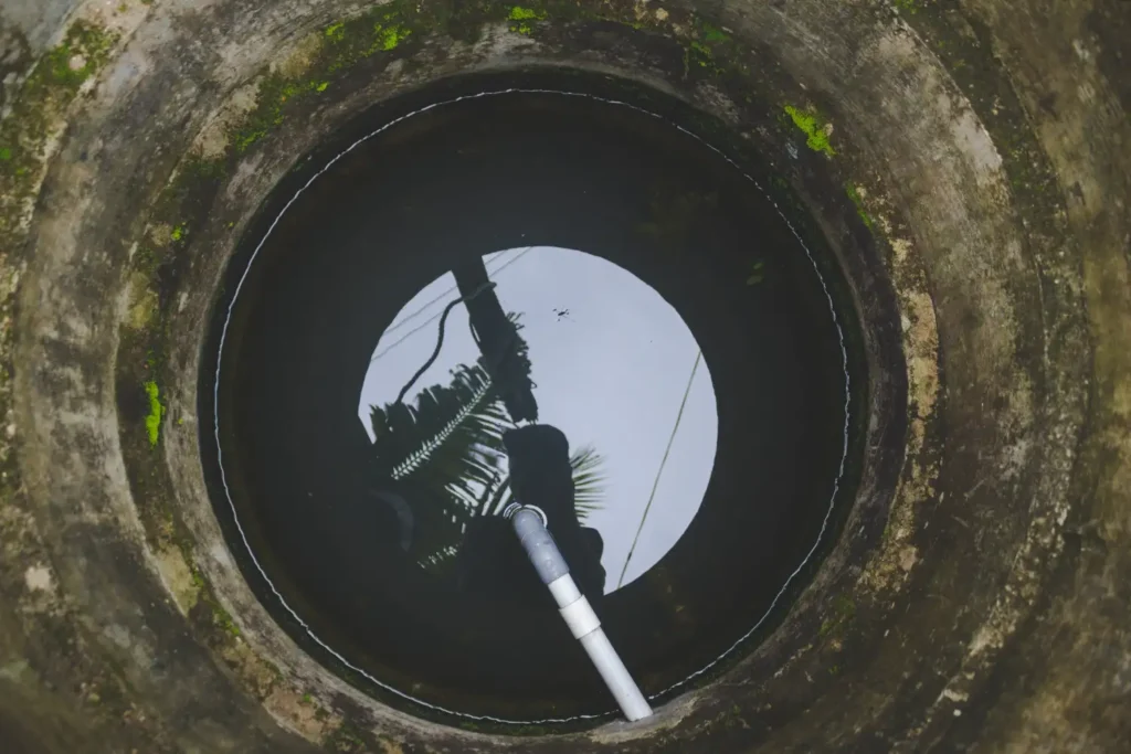 Inside view of septic tank during professional septic tank pumping services using a vacuum hose